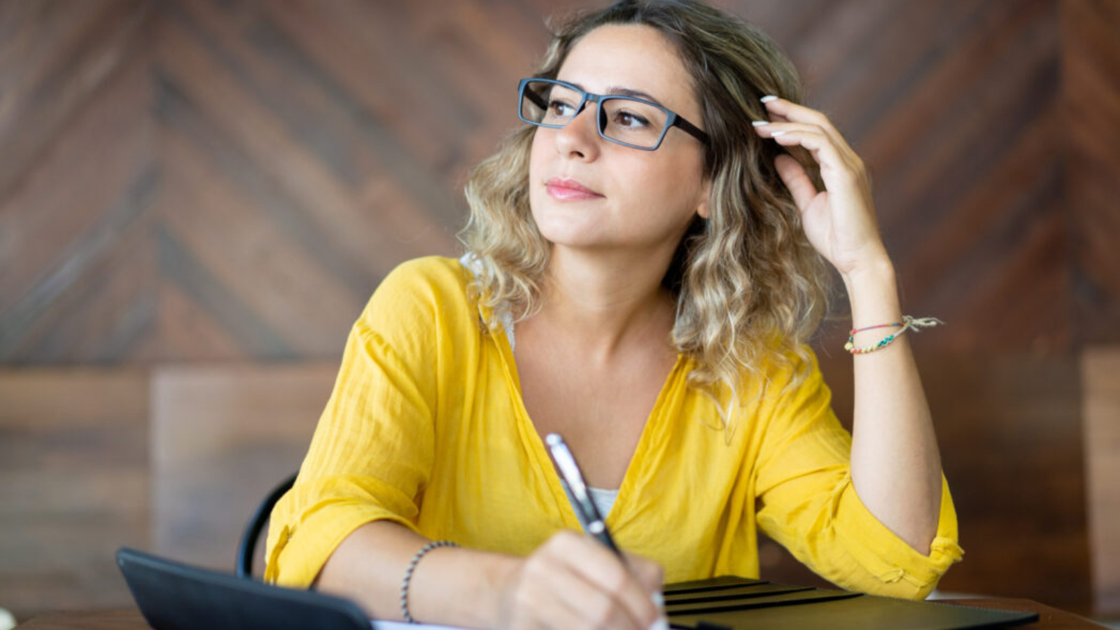 Inspired creative woman writing down ideas. Young business lady writing schedule on blank paper sheet. Working process concept