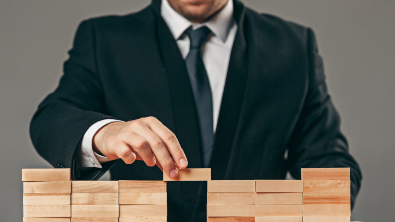 Man and wooden cubes on table. Management and marketing concepts