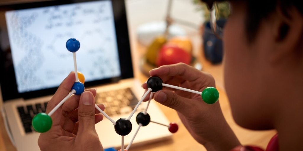 Close-up image of chemical element model in hands on student