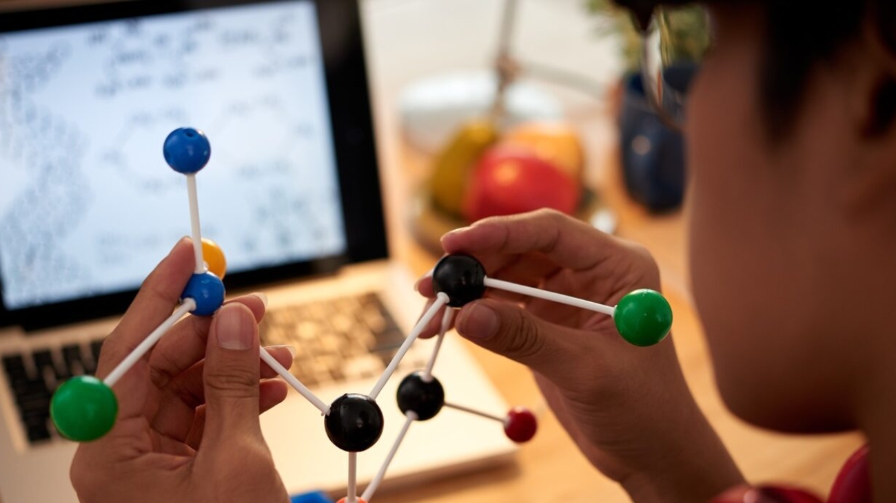 Close-up image of chemical element model in hands on student