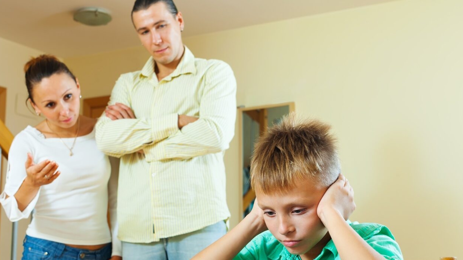 Parents berates her teenage child in interior. Focus on boy only